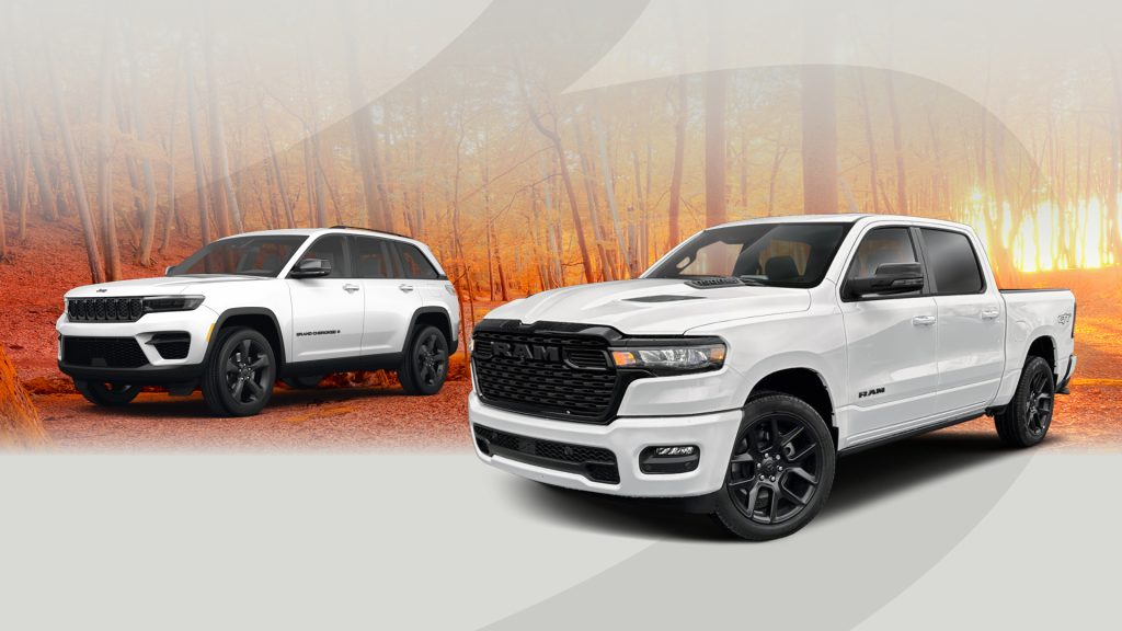 White Jeep Grand Cherokee and white RAM pickup truck displayed on a road surrounded by autumn trees with orange leaves and a soft sunrise in the background. The image has a warm, seasonal tone suitable for a fall-themed automotive promotion.