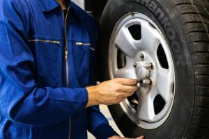 mechanic putting tire on vehicle