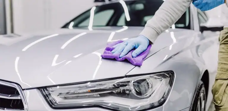 silver car being detailed with purple rag