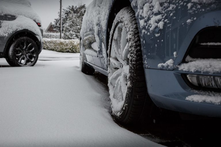 tight shot of wheel on car parked in snow
