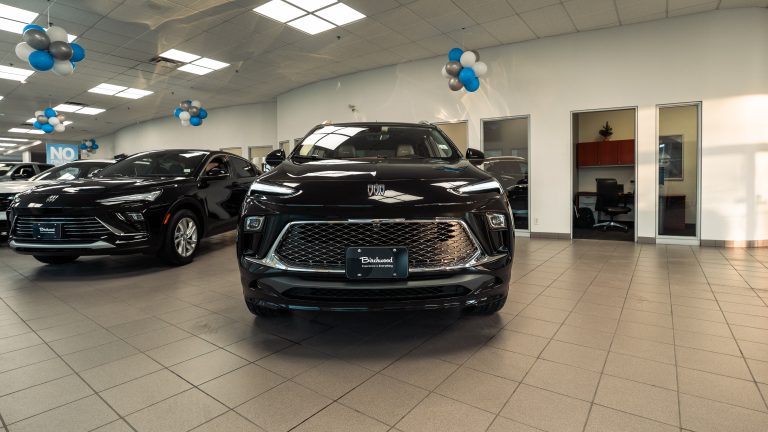 black 2026 Buick Encore gx sitting in showroom facing camera head-on