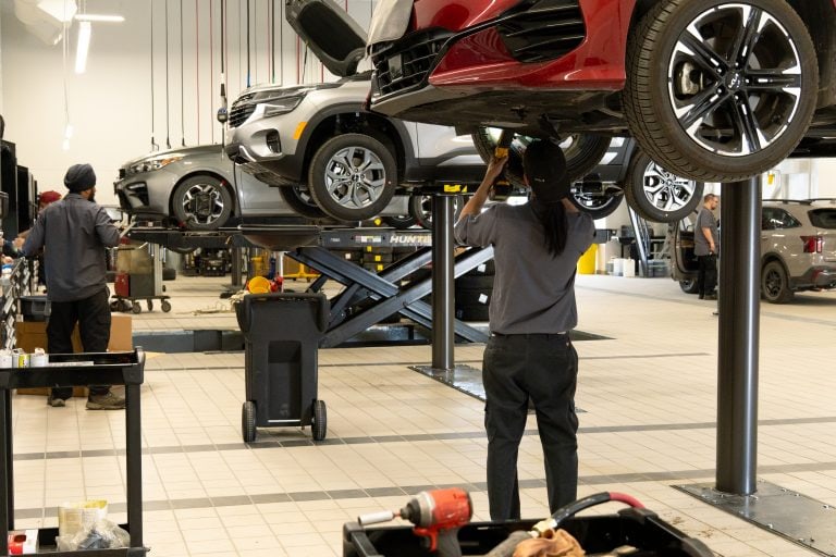 technicians working on vehicles in service shop