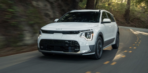 white 2026 kia niro ev driving down highway