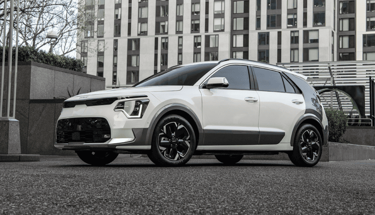 white 2026 kia niro ev parked infront of tall building