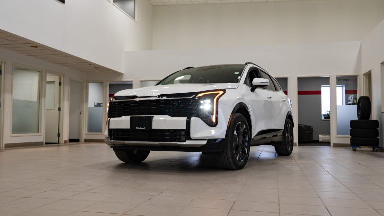 white 2026 kia Sportage in an empty showroom