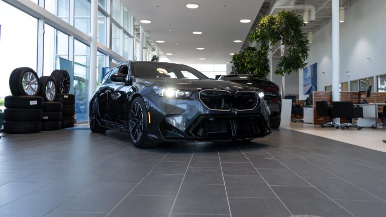 grey 2026 bmw m5 parked in bright showroom