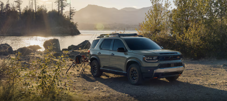honda passport parked near lake with trees in background, fishing equipment set up behind the vehicle