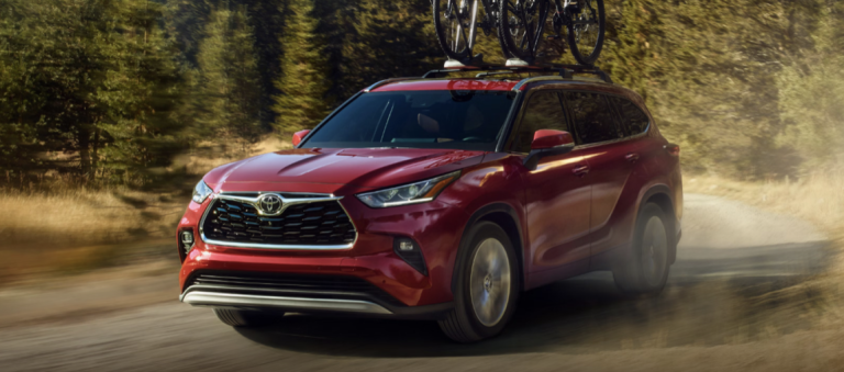 red toyota highlander driving on highway