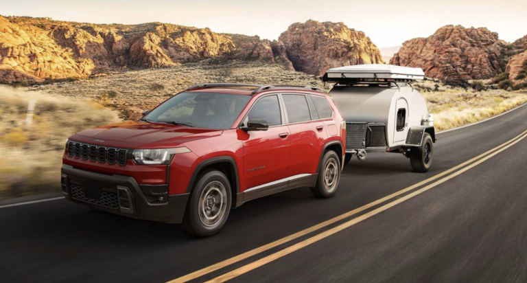 jeep cherokee driving down road pulling small trailer